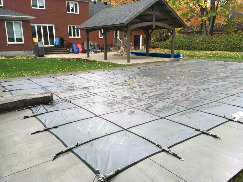 Grey Latham Swimming Pool Safety Cover with a diving rock | HB Pools Pool Closing