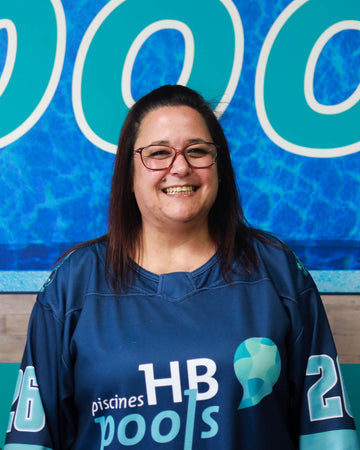 Head office staff wearing an HB Pools shirt in front of a large HB Pools sign.