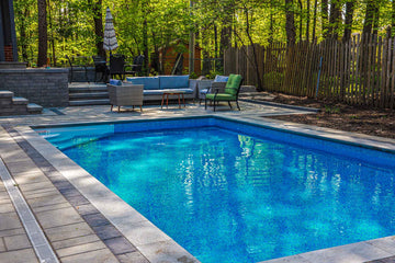 Inground Rectangle Pool 14x28 with Interlock pool surround and cozy seating and dining areas.