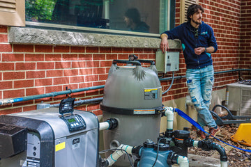 HB Pools technician leaning on brick house next to the Inground Pool Equipment
