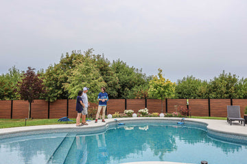 HB Pools technician consulting with homeowners beside a vinyl inground swimming pool in Greely, Ontario, providing expert pool maintenance advice in a beautifully landscaped backyard
