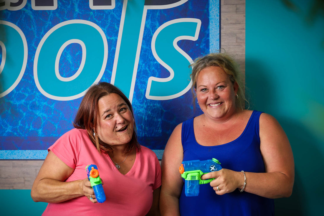 Portrait of Julie & Dyana at HB Pools Office playing around with pool toys