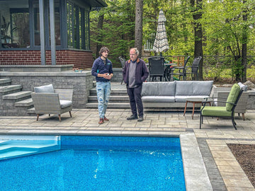 Homeowner and Pool technician discussing pool maintenance near the pool edge.