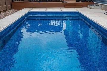 Close-up of built-in vinyl inground pool steps and deep blue patterned liner, surrounded by concrete coping, installed by HB Pools in Orleans, Ontario.