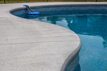 Close-up of smooth concrete pool deck edge and textured vinyl liner of an inground pool installed by HB Pools in Greely, Ontario, showcasing quality craftsmanship and durable materials.