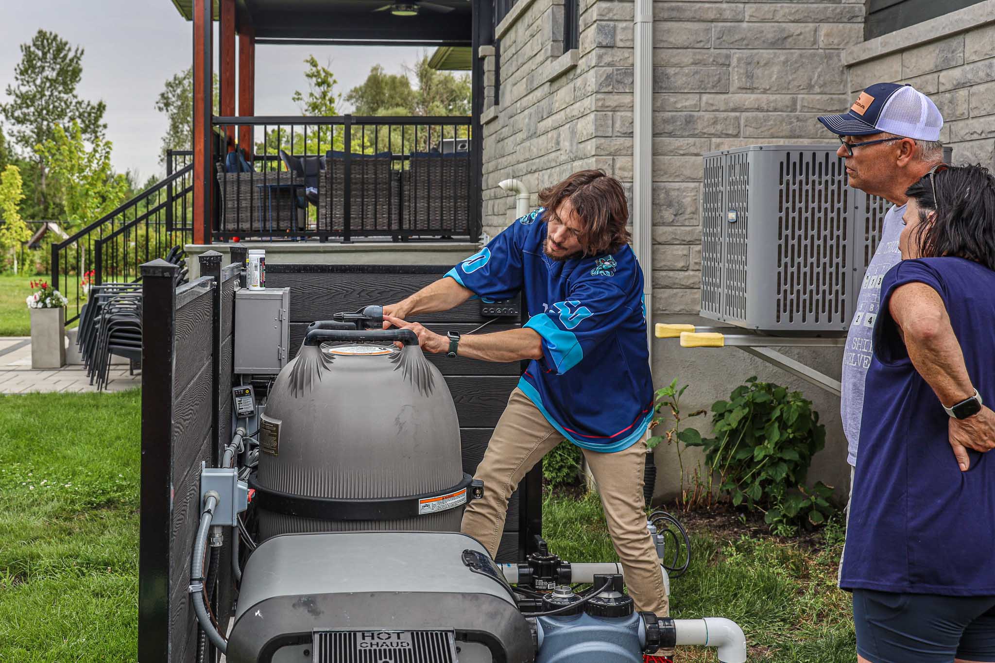 HB Pools technician inspecting and servicing pool filtration equipment for homeowners in Greely, Ontario, demonstrating expert pool maintenance and customer care.