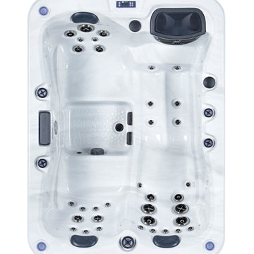 Top-down view of a white outdoor hot tub with multiple jet nozzles and dark gray control panels on a white background.