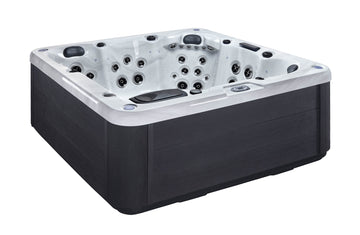 A rectangular outdoor hot tub with a black exterior and a white interior, featuring multiple built-in jet nozzles and a control panel on the side, shown against a plain white background.