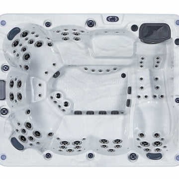 Top-down view of a white hot tub with multiple black and gray jet nozzles and controls, isolated on a white background.