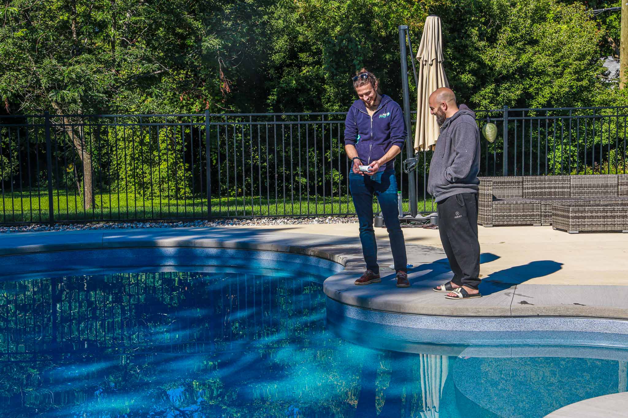 HB Pools Installation specialist talks with Ottawa homeowner around a new freeform pool construction project
