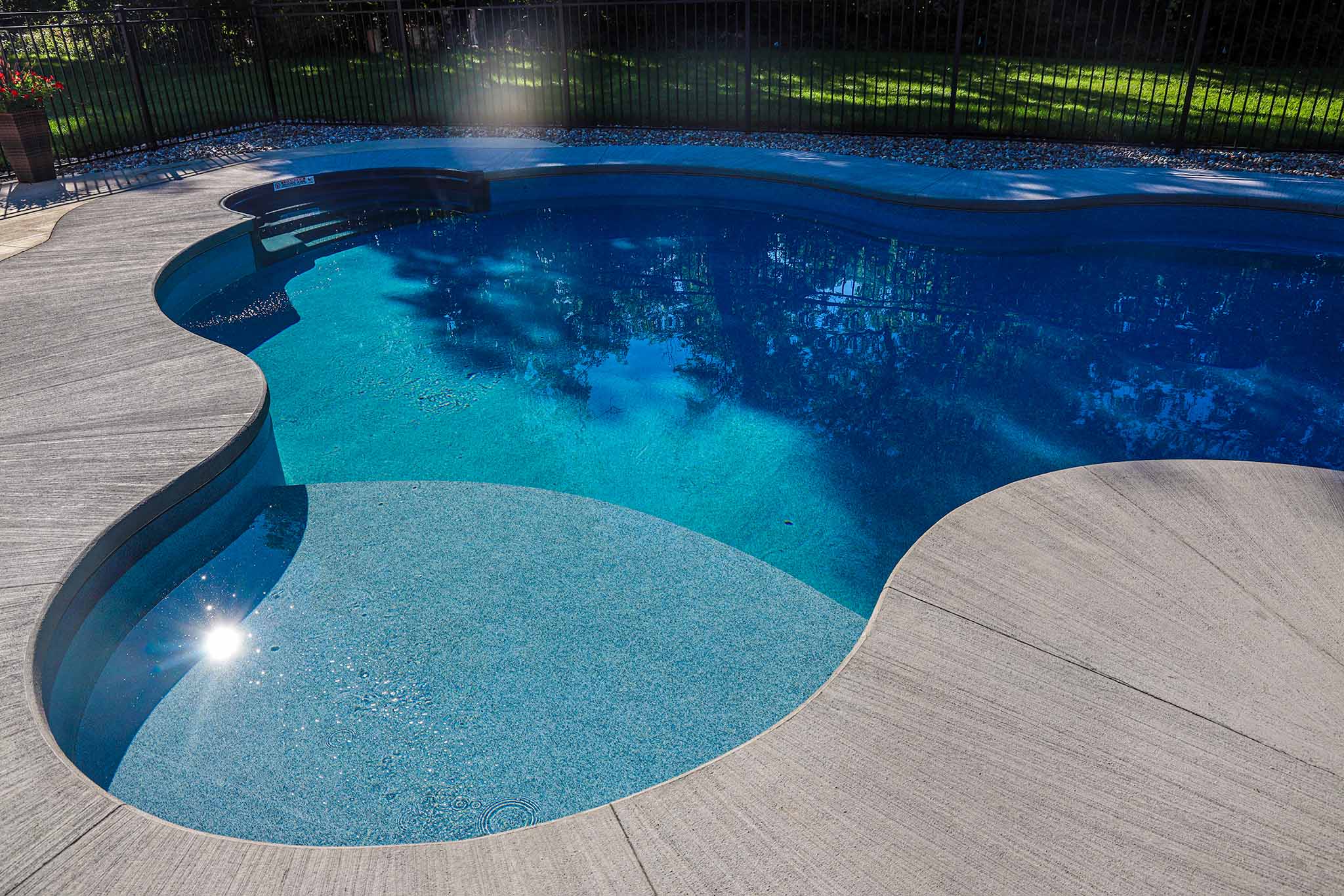 New curved pool installation in Ottawa with freeform tanning ledge