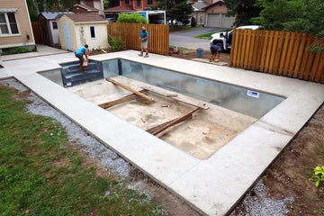 Construction of a swimming pool with workers and materials on a residential property | HB Pools