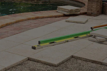 Pool repair and renovation project showing patio leveling and deck restoration around an inground swimming pool.