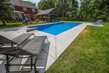Backyard with a pool, lounge chairs, and a gazebo on a sunny day | HB Pools