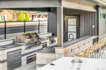 Backyard Pool BBQ and Bar space with custom pavers , Outdoor kitchen and barstools under a patio Cover.