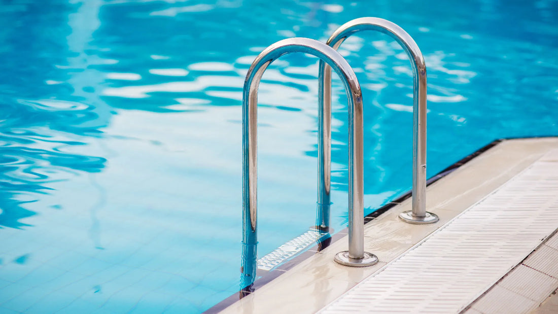 Clean blue swimming pool with polished chrome ladder after professional pool opening services | HB Pools