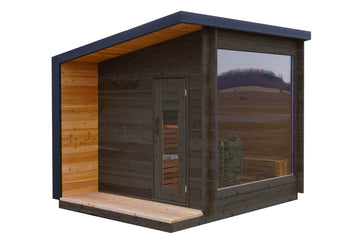 A modern wooden sauna cabin with dark brown exterior wood panels, a warm honey-toned wood interior, a small wooden porch, and a large glass window showing an outdoor landscape view.