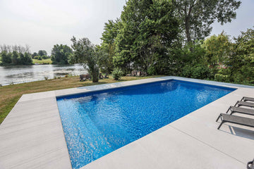 rectangular inground pool with blue vinyl liner and concrete patio in Manotick Ontario
