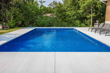 rectangular inground pool with blue vinyl liner and concrete patio in Manotick Ontario